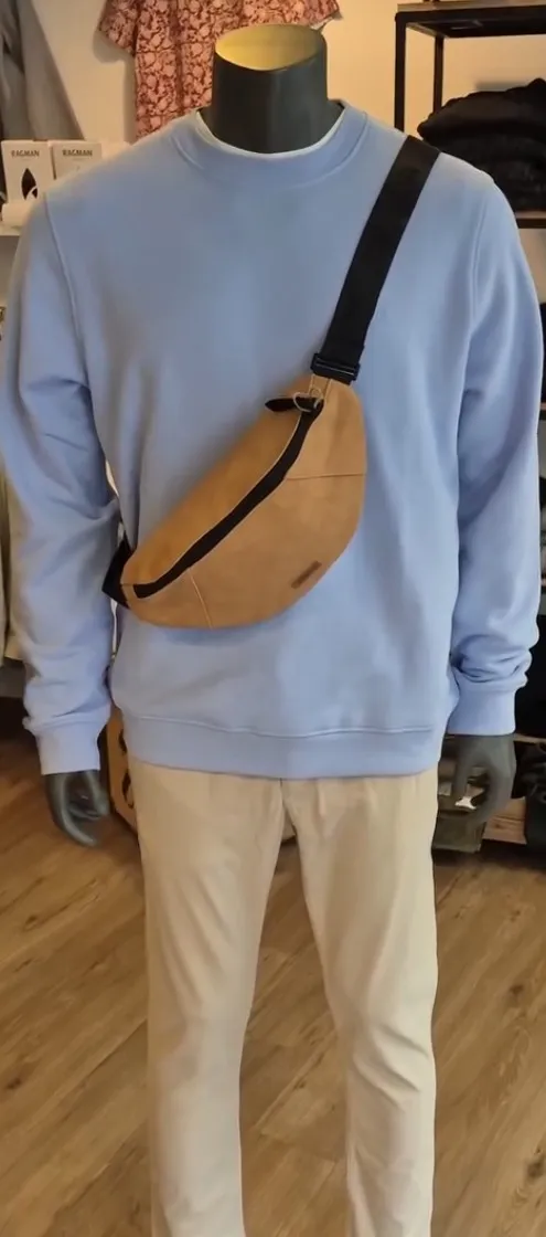 Hellblauer Sweater kombiniert mit sandfarbener Cross-Body-Tasche und heller Chino