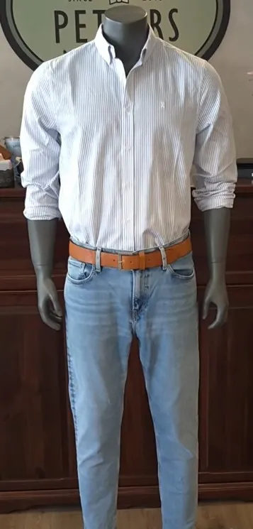 Herrenhemd mit feinem Streifenmuster und Jeans auf einer Schaufensterpuppe im Laden von Petters Men's Fashion, im Hintergrund das Petters-Logo